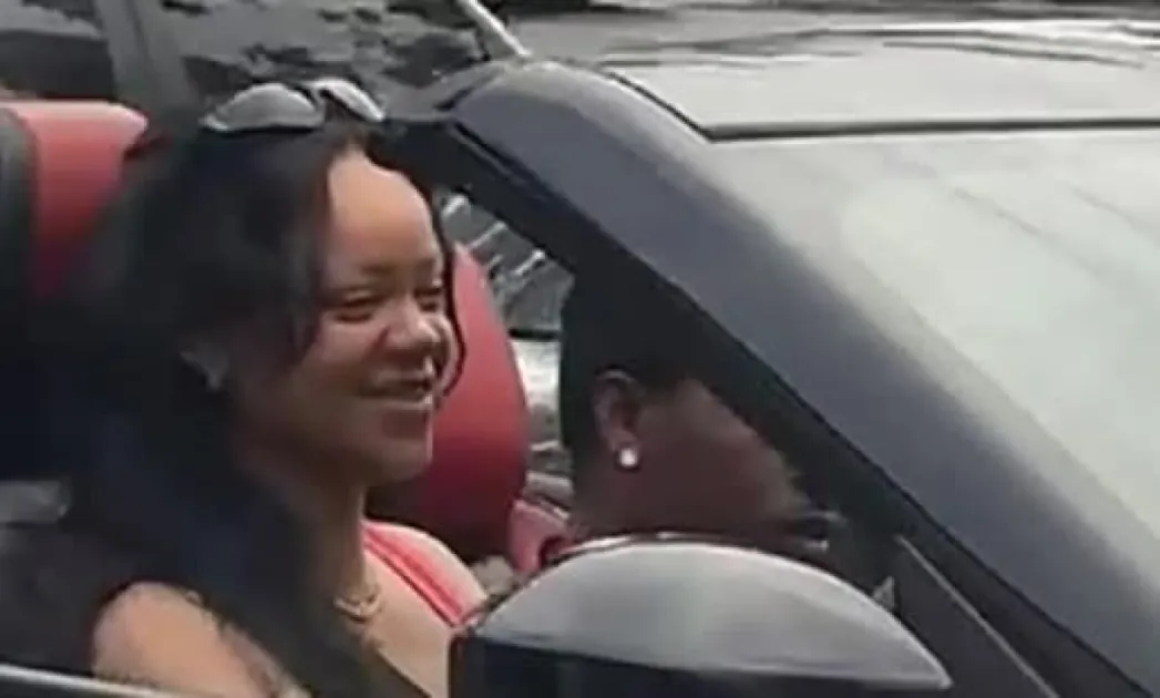 Rihanna, with messy hair and sunglasses, was spotted driving in a hot pink tank top, while her husband wore a black tee.