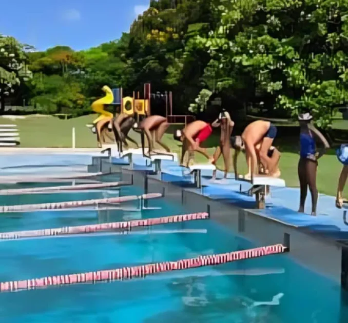 The competition features swimmers from local clubs and a visiting British Virgin Islands club, competing across multiple age categories for a chance to join the national squad for CARIFTA.
